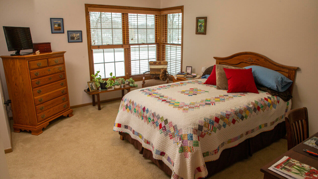 Bedroom with a colorful quilt on its bed